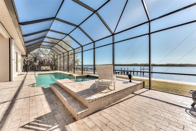 view of swimming pool with a patio area, glass enclosure, and a water view