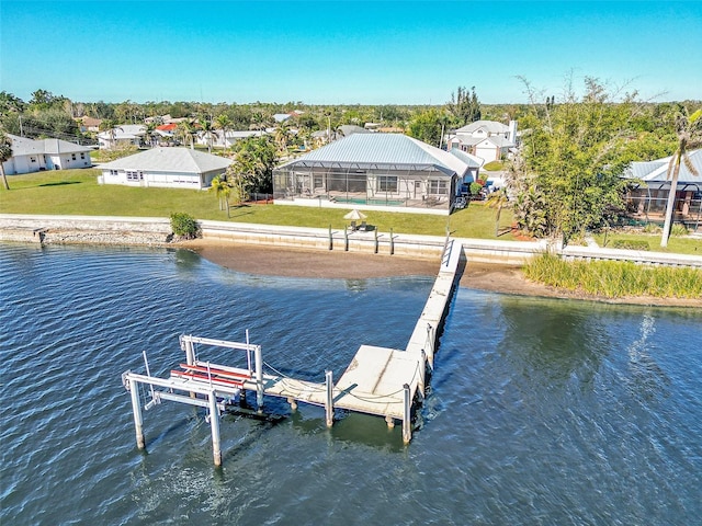 dock area featuring glass enclosure, a water view, and a lawn