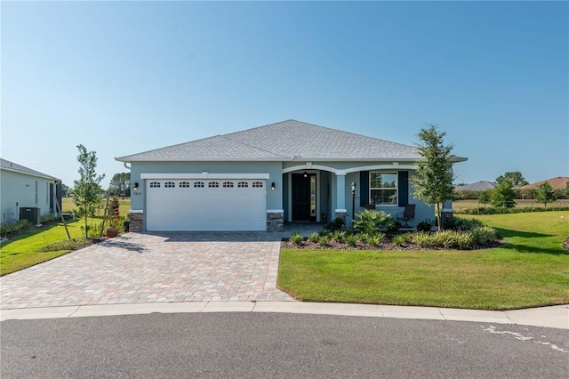 view of front facade featuring a front lawn, cooling unit, and a garage