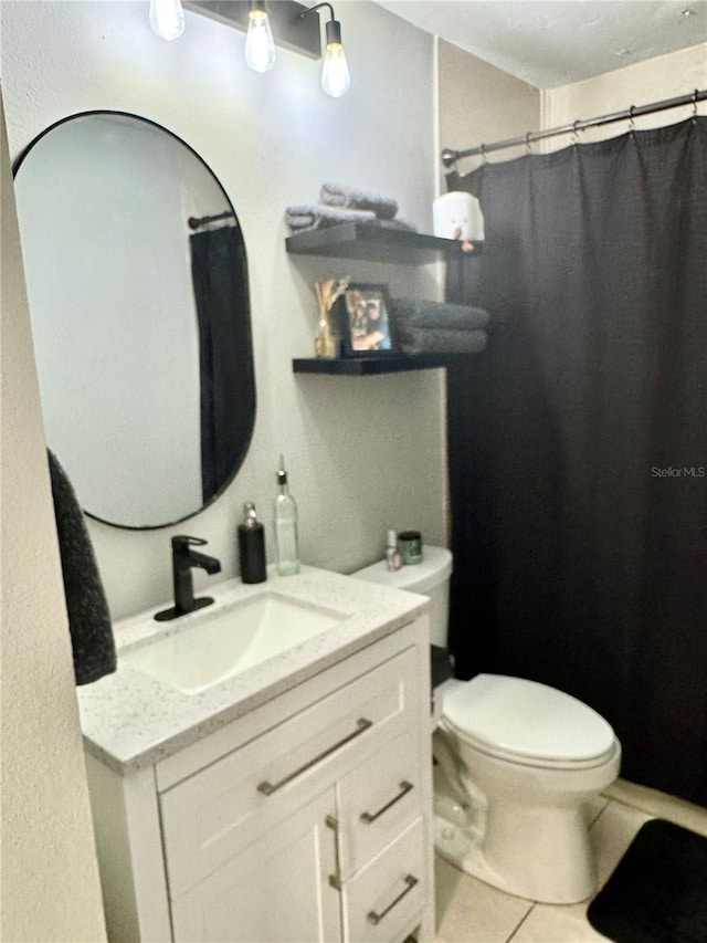 bathroom with tile patterned flooring, vanity, and toilet