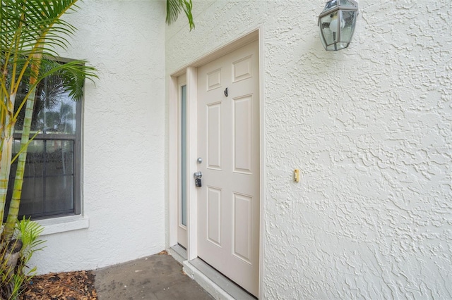 property entrance with stucco siding