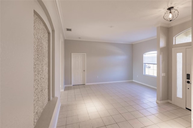 tiled foyer featuring a notable chandelier and ornamental molding