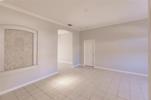 empty room with crown molding and light tile patterned flooring