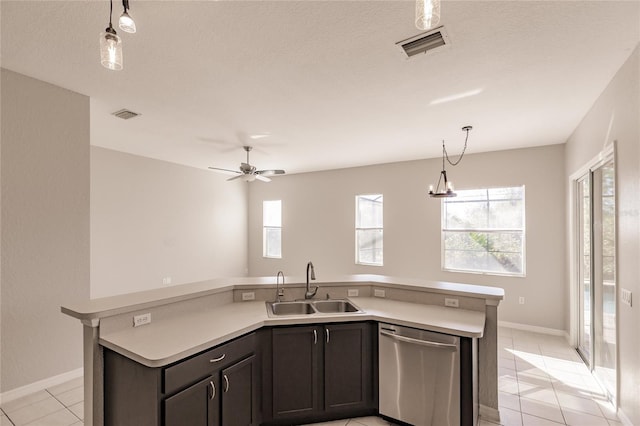 kitchen featuring stainless steel dishwasher, ceiling fan with notable chandelier, sink, light tile patterned floors, and an island with sink