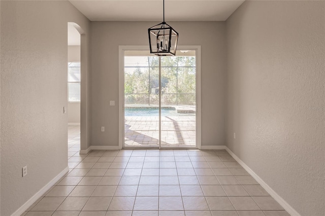 doorway to outside featuring light tile patterned floors and a notable chandelier