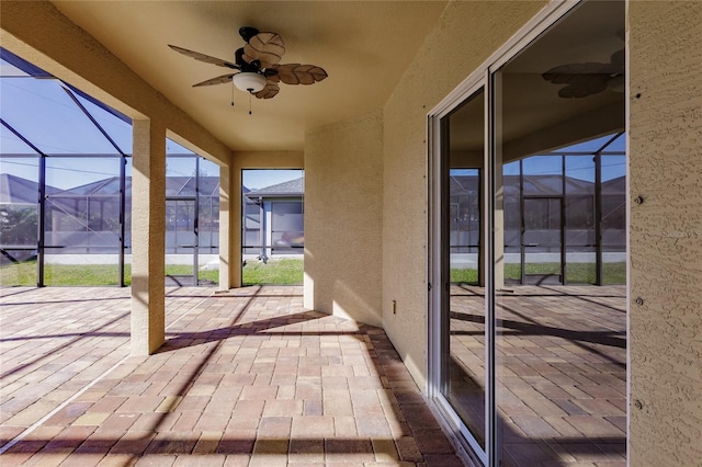 unfurnished sunroom with ceiling fan