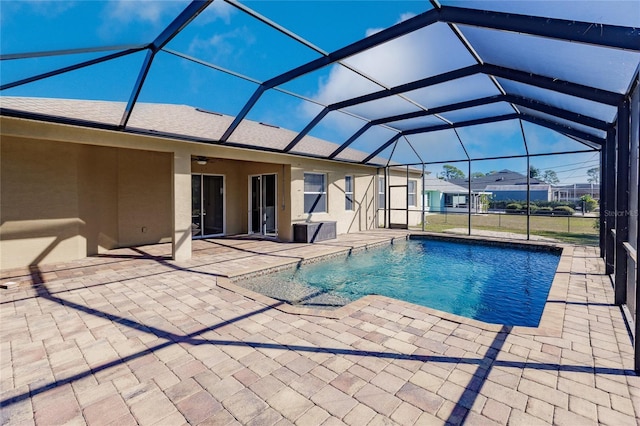 view of pool featuring glass enclosure, ceiling fan, and a patio area