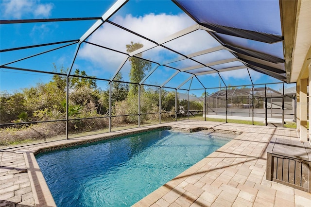 view of swimming pool with glass enclosure and a patio area