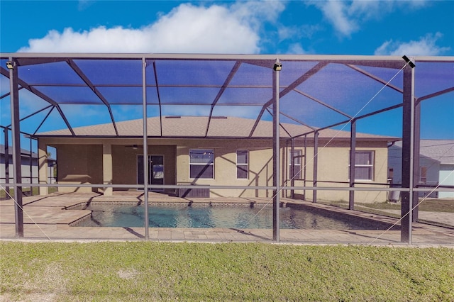 back of house with a lawn, ceiling fan, a patio area, and a lanai