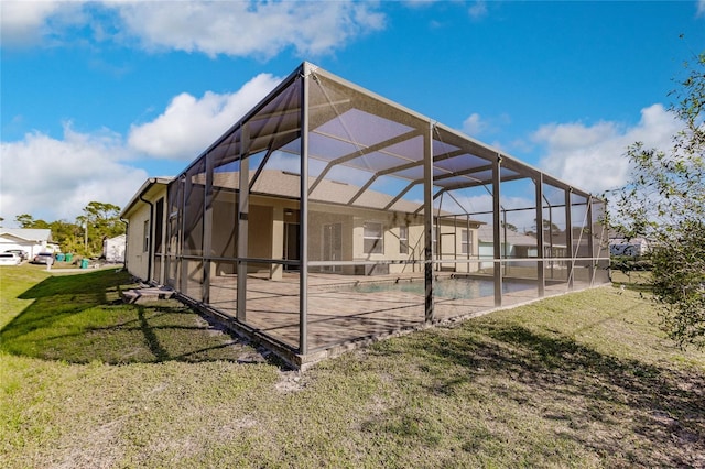 exterior space with a patio, glass enclosure, a swimming pool, and a lawn