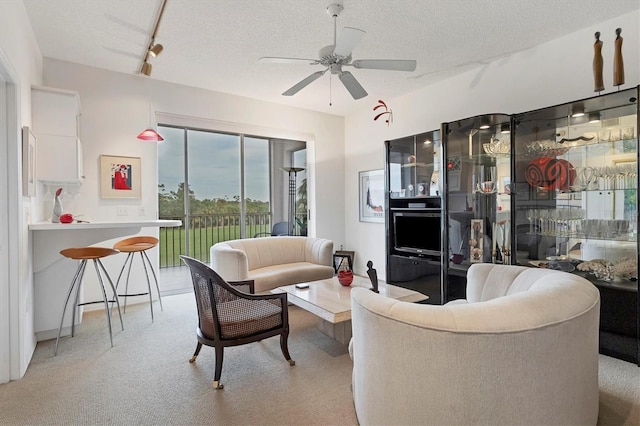 living room with ceiling fan and a textured ceiling