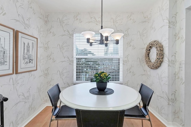 dining space featuring hardwood / wood-style flooring and a chandelier