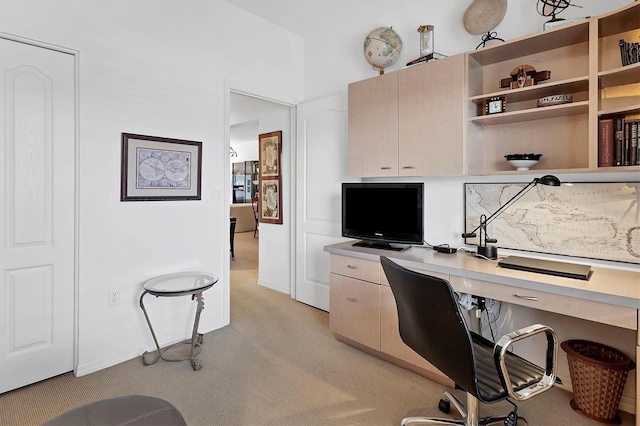 carpeted home office featuring built in desk