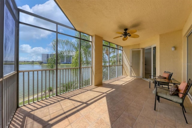 sunroom / solarium with ceiling fan, a water view, and plenty of natural light