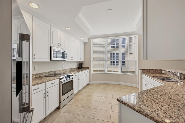 kitchen featuring appliances with stainless steel finishes, a sink, stone countertops, white cabinets, and ornamental molding