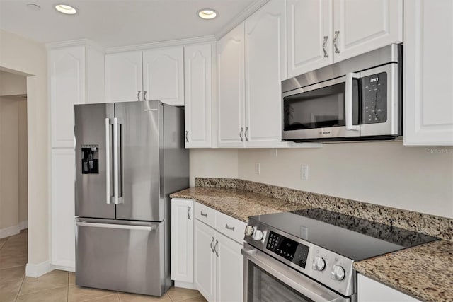 kitchen with stainless steel appliances, white cabinetry, light tile patterned flooring, recessed lighting, and light stone counters