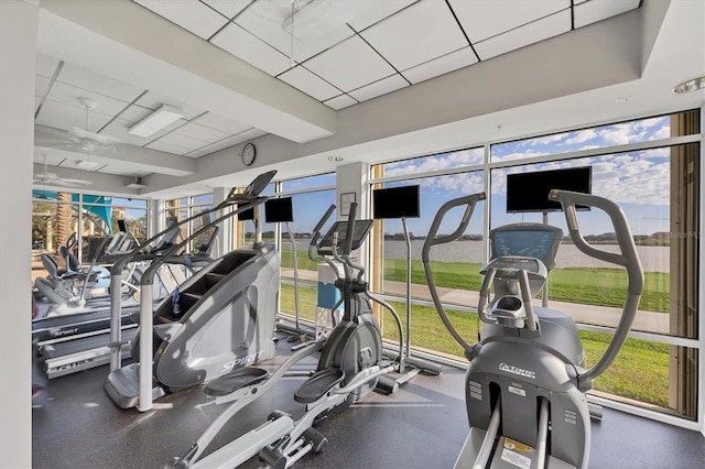 gym with a paneled ceiling and ceiling fan