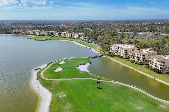 bird's eye view of a nearby body of water, a golf club, apartment complex, and a tree filled landscape