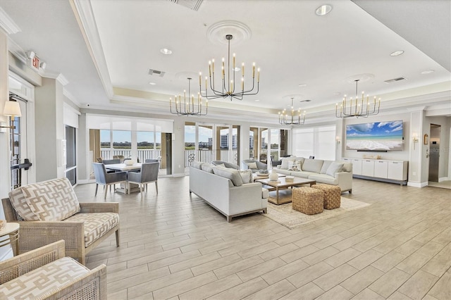 living room with a tray ceiling, a chandelier, recessed lighting, crown molding, and baseboards