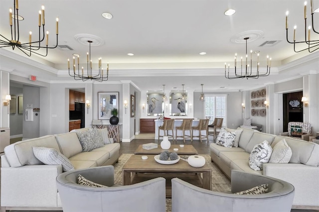 living room with a chandelier, ornamental molding, recessed lighting, a raised ceiling, and wood finished floors