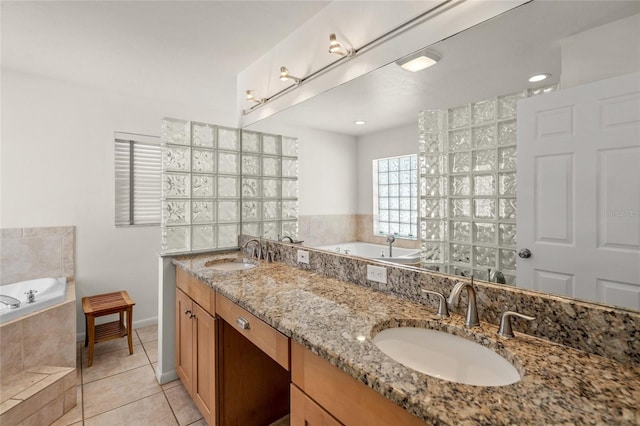 bathroom featuring tile patterned floors, vanity, and tiled bath