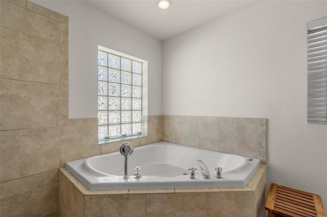 bathroom featuring a relaxing tiled tub and plenty of natural light