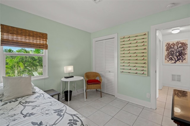 bedroom with light tile patterned flooring and a closet