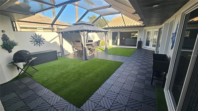 view of yard featuring glass enclosure, a patio, and french doors