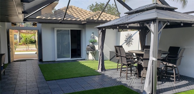 view of patio / terrace featuring a gazebo, outdoor dining area, and a lanai