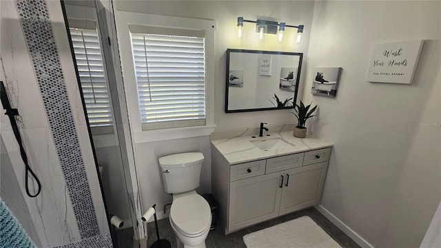 full bath featuring toilet, a shower stall, baseboards, and vanity