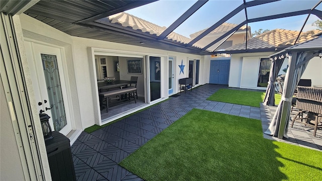 view of yard featuring glass enclosure and a patio area