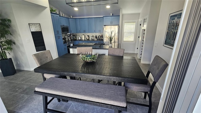 tiled dining area featuring vaulted ceiling and sink