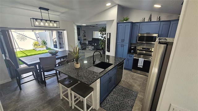 kitchen with sink, appliances with stainless steel finishes, blue cabinetry, and vaulted ceiling