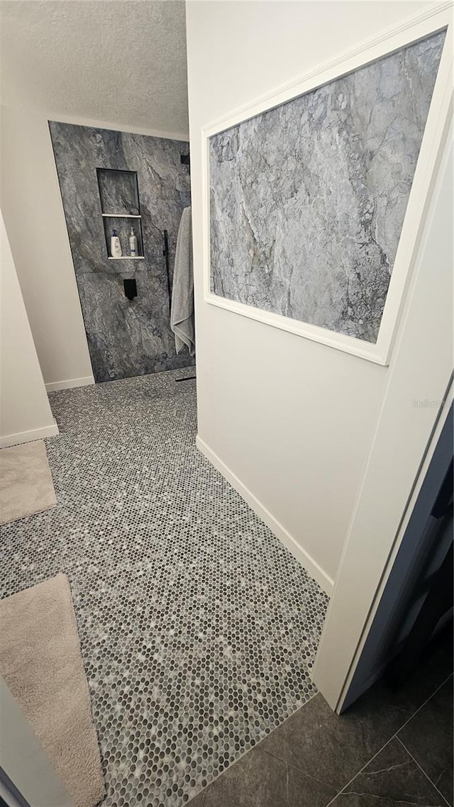 bathroom with baseboards and a textured ceiling