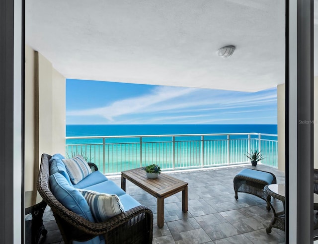 balcony featuring an outdoor living space and a water view