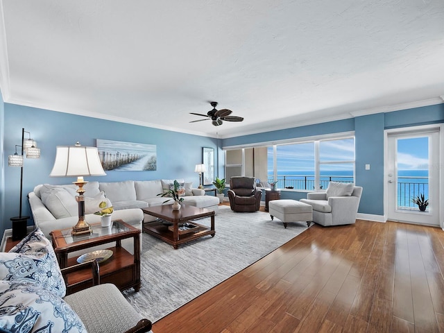 living room featuring a water view, crown molding, ceiling fan, and hardwood / wood-style flooring