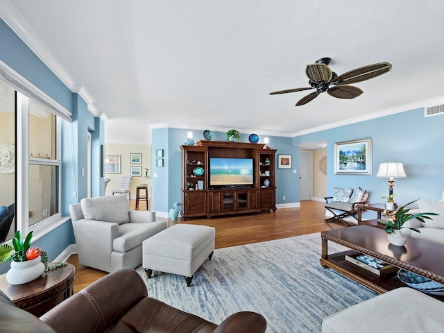 living room featuring hardwood / wood-style floors, ceiling fan, and crown molding