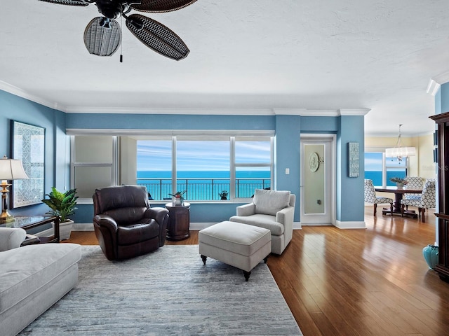 living room with a wealth of natural light, a water view, ceiling fan, and hardwood / wood-style flooring