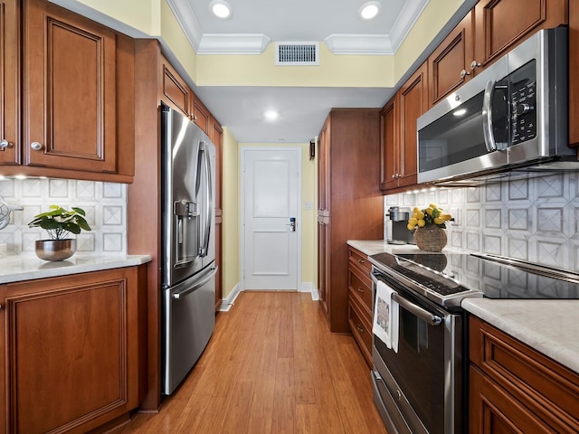 kitchen with decorative backsplash, ornamental molding, appliances with stainless steel finishes, and light hardwood / wood-style flooring