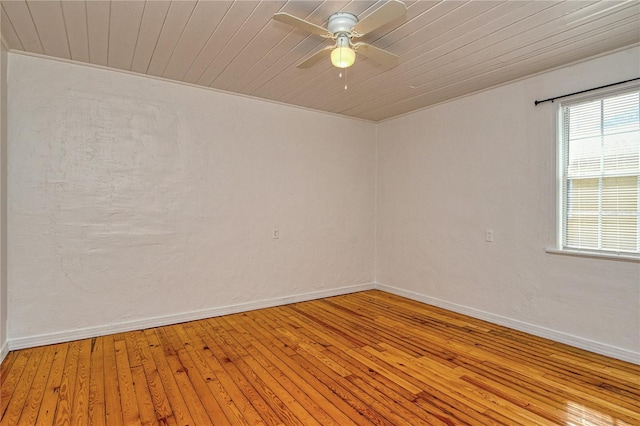 spare room featuring ceiling fan, light wood-type flooring, and wooden ceiling