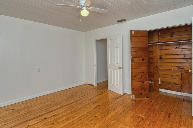 unfurnished bedroom with ceiling fan, a closet, wooden ceiling, and light hardwood / wood-style floors