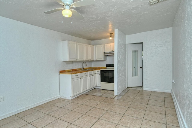 kitchen with electric stove, light tile patterned floors, sink, and white cabinetry