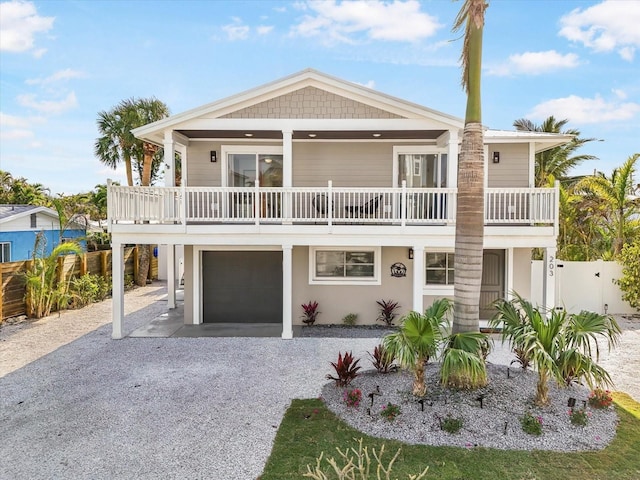 raised beach house featuring a balcony and a garage