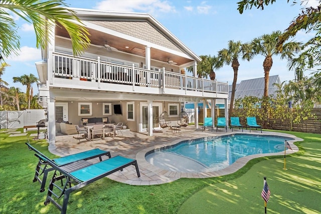 rear view of house with a balcony, a patio area, ceiling fan, and a fenced in pool