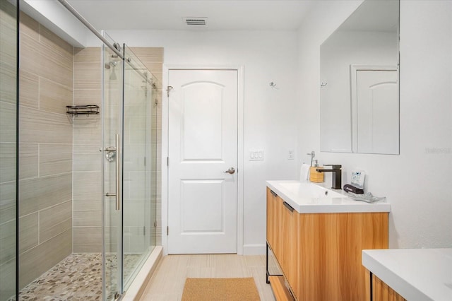 bathroom with walk in shower and vanity