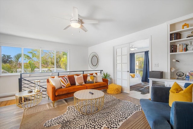 living room with ceiling fan, french doors, and light wood-type flooring