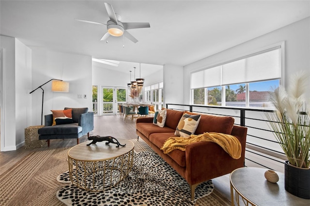 living room with ceiling fan, a healthy amount of sunlight, hardwood / wood-style floors, and vaulted ceiling