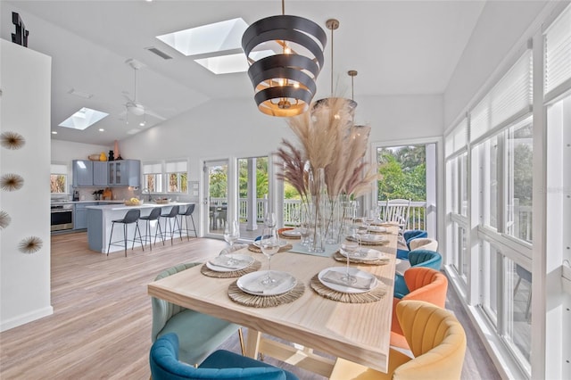 dining area featuring light hardwood / wood-style floors, a skylight, and a wealth of natural light