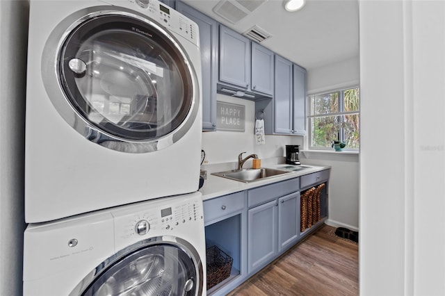 clothes washing area featuring sink, dark hardwood / wood-style flooring, and stacked washer / dryer