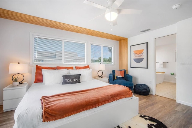 bedroom featuring ceiling fan, hardwood / wood-style floors, and connected bathroom